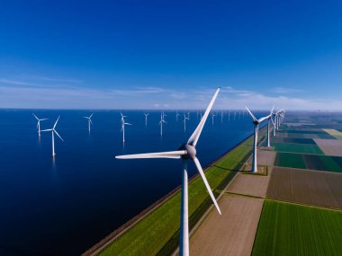 Bulutları ve mavi gökyüzü olan off-shore yel değirmeni parkı, okyanus drone parkı rüzgar türbini Flevoland Hollanda Ijsselmeer ile hava manzaralı