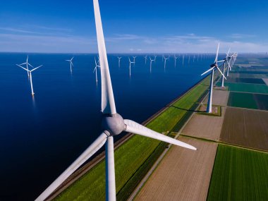 Bulutları ve mavi gökyüzü olan off-shore yel değirmeni parkı, okyanus drone parkı rüzgar türbini Flevoland Hollanda Ijsselmeer ile hava manzaralı