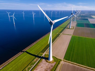 Bulutları ve mavi gökyüzü olan off-shore yel değirmeni parkı, okyanus drone parkı rüzgar türbini Flevoland Hollanda Ijsselmeer ile hava manzaralı
