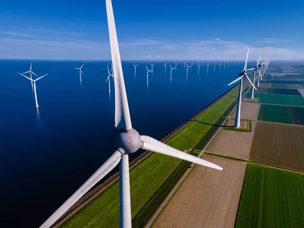 Bulutları ve mavi gökyüzü olan off-shore yel değirmeni parkı, okyanus drone parkı rüzgar türbini Flevoland Hollanda Ijsselmeer ile hava manzaralı