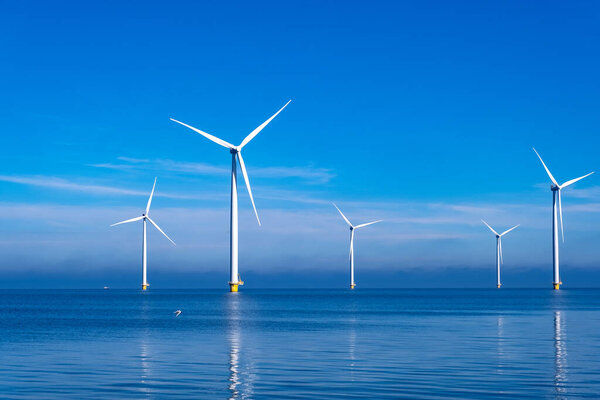 offshore windmill park with clouds and a blue sky, windmill park in the ocean drone aerial view with wind turbine Flevoland Netherlands Ijsselmeer
