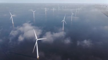 Bulutları ve mavi gökyüzü olan off-shore yel değirmeni parkı, okyanus drone parkı rüzgar türbini Flevoland Hollanda Ijsselmeer ile hava manzaralı