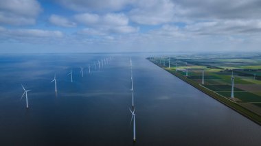 Bulutları ve mavi gökyüzü olan off-shore yel değirmeni parkı, okyanus drone parkı rüzgar türbini Flevoland Hollanda Ijsselmeer ile hava manzaralı