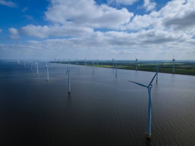 Bulutları ve mavi gökyüzü olan off-shore yel değirmeni parkı, okyanus drone parkı rüzgar türbini Flevoland Hollanda Ijsselmeer ile hava manzaralı