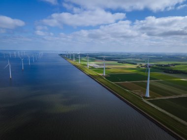 Bulutları ve mavi gökyüzü olan off-shore yel değirmeni parkı, okyanus drone parkı rüzgar türbini Flevoland Hollanda Ijsselmeer ile hava manzaralı