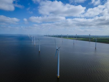 Bulutları ve mavi gökyüzü olan off-shore yel değirmeni parkı, okyanus drone parkı rüzgar türbini Flevoland Hollanda Ijsselmeer ile hava manzaralı
