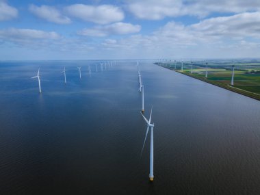 Bulutları ve mavi gökyüzü olan off-shore yel değirmeni parkı, okyanus drone parkı rüzgar türbini Flevoland Hollanda Ijsselmeer ile hava manzaralı