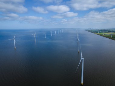 Bulutları ve mavi gökyüzü olan off-shore yel değirmeni parkı, okyanus drone parkı rüzgar türbini Flevoland Hollanda Ijsselmeer ile hava manzaralı