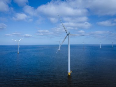 Bulutları ve mavi gökyüzü olan off-shore yel değirmeni parkı, okyanus drone parkı rüzgar türbini Flevoland Hollanda Ijsselmeer ile hava manzaralı