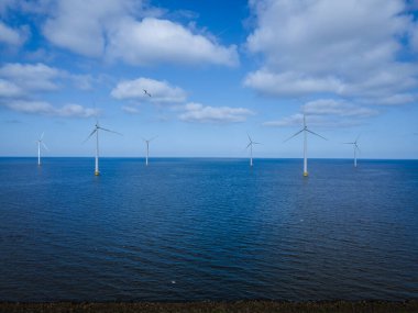 Bulutları ve mavi gökyüzü olan off-shore yel değirmeni parkı, okyanus drone parkı rüzgar türbini Flevoland Hollanda Ijsselmeer ile hava manzaralı