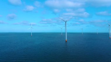 Bulutları ve mavi gökyüzü olan off-shore yel değirmeni parkı, okyanus drone parkı rüzgar türbini Flevoland Hollanda Ijsselmeer ile hava manzaralı