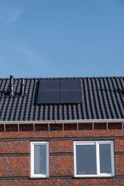 Güneşli bir gökyüzüne bağlı güneş panelleri olan yeni evler inşa edin. Siyah güneş panelleri olan yeni binaları kapatın. Zonnepanelen, Zonne enerjisi, Çevirisi: Güneş paneli, Güneş Enerjisi