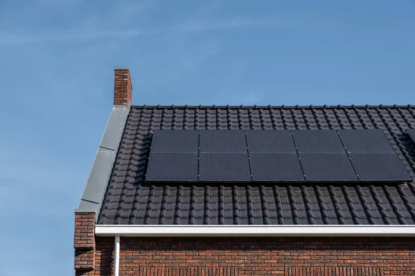 Güneşli bir gökyüzüne bağlı güneş panelleri olan yeni evler inşa edin. Siyah güneş panelleri olan yeni binaları kapatın. Zonnepanelen, Zonne enerjisi, Çevirisi: Güneş paneli, Güneş Enerjisi — Stok fotoğraf