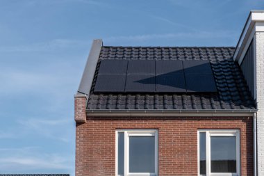 Güneşli bir gökyüzüne bağlı güneş panelleri olan yeni evler inşa edin. Siyah güneş panelleri olan yeni binaları kapatın. Zonnepanelen, Zonne enerjisi, Çevirisi: Güneş paneli, Güneş Enerjisi