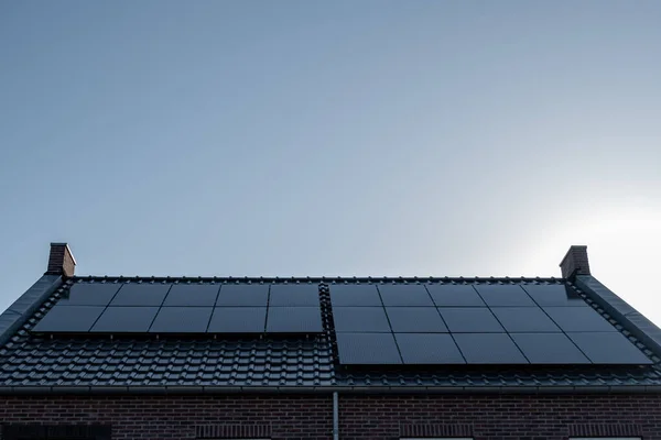 Newly build houses with solar panels attached on the roof against a sunny sky Close up of new building with black solar panels. Zonnepanelen, Zonne energie, Translation: Solar panel, , Sun Energy — Stock Photo, Image