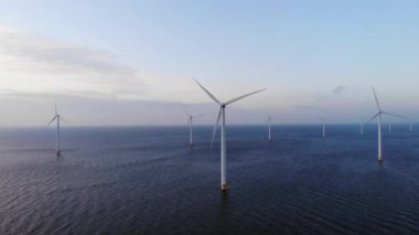 Bulutları ve mavi gökyüzü olan off-shore yel değirmeni parkı, okyanus drone parkı rüzgar türbini Flevoland Hollanda Ijsselmeer ile hava manzaralı