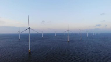 Bulutları ve mavi gökyüzü olan off-shore yel değirmeni parkı, okyanus drone parkı rüzgar türbini Flevoland Hollanda Ijsselmeer ile hava manzaralı