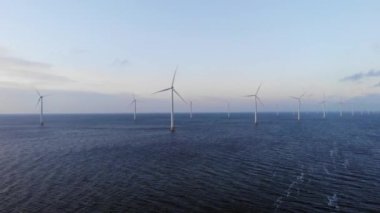 Bulutları ve mavi gökyüzü olan off-shore yel değirmeni parkı, okyanus drone parkı rüzgar türbini Flevoland Hollanda Ijsselmeer ile hava manzaralı