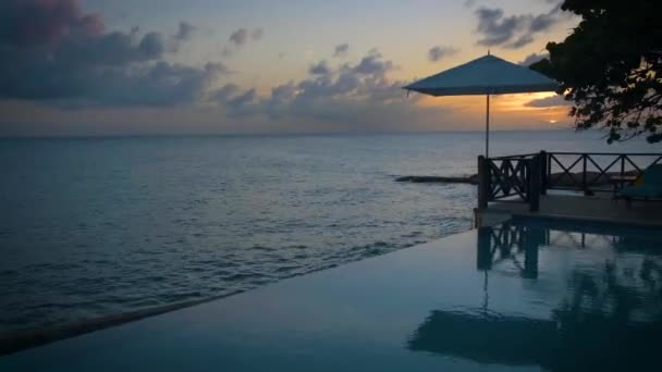 Curacao, Curacao 'da tatilde olan bir çift havuz kenarında gün batımını izliyor. — Stok video