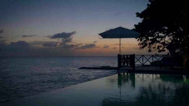 Curacao, par på semester i Curacao tittar på solnedgången vid poolen — Stockvideo