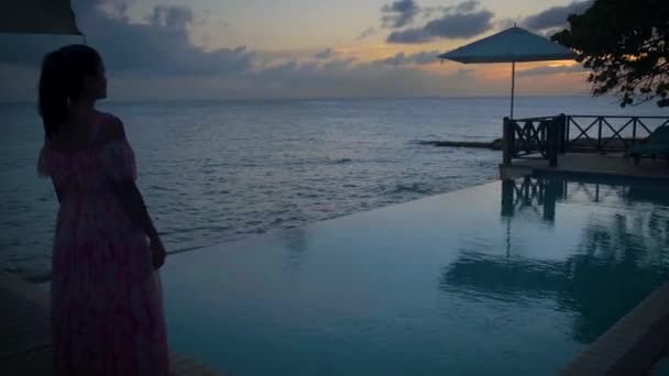 Curacao, par på semester i Curacao tittar på solnedgången vid poolen — Stockvideo