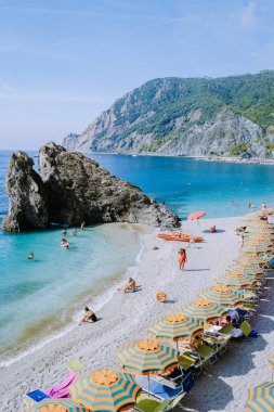 Sandalyeler ve şemsiyeler Spiaggia di fegina plajını dolduruyor. İtalya Cinque Terre 'nin bir parçası olan Monterosso İtalya' nın geniş kumlu sahil köyünü.