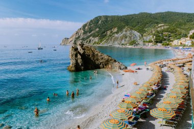  Sandalyeler ve şemsiyeler Spiaggia di fegina plajını dolduruyor. İtalya Cinque Terre 'nin bir parçası olan Monterosso İtalya' nın geniş kumlu sahil köyünü.