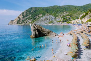  Sandalyeler ve şemsiyeler Spiaggia di fegina plajını dolduruyor. İtalya Cinque Terre 'nin bir parçası olan Monterosso İtalya' nın geniş kumlu sahil köyünü.