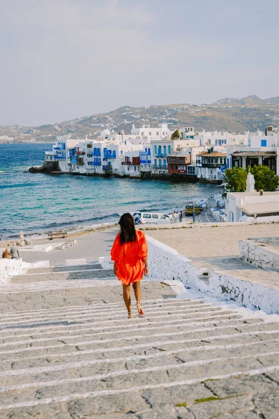 Mykonos Greece, Young woman in dress at the Streets of old town Mikonos during vacation in Greece, Little Venice Mykonos Greece