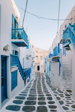 Mykonos Greece , colorful streets of the old town of Mykonos with tourist in the street clipart