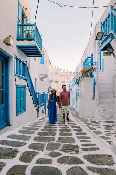 Mykonos Griechenland, Junge Männer und Frauen in Kleidern auf den Straßen der Altstadt von Mikonos während ihres Urlaubs in Griechenland, Klein Venedig Mykonos Griechenland — Stockfoto