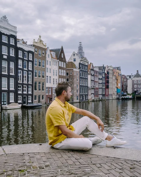 Amsterdam Hollanda, Amsterdam Kanalları 'nda bir yaz akşamında mutlu bir çift. Orta yaşlı erkek ve kadın Asyalı kız ve Avrupalı erkekler şehir gezisinde — Stok fotoğraf