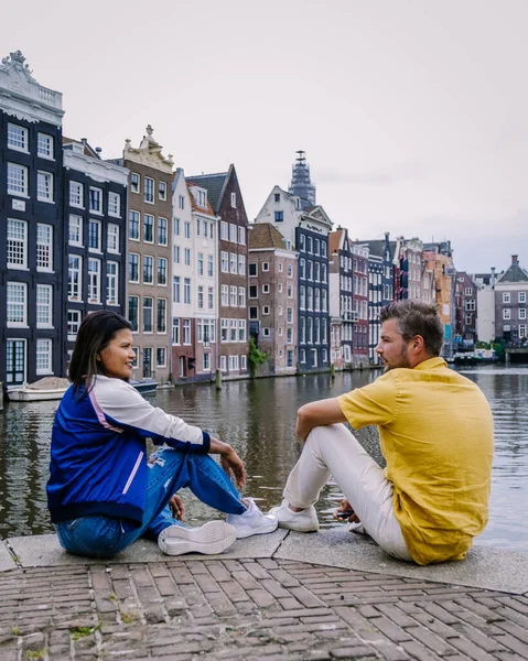 Amsterdam Países Bajos, pareja feliz hombre y mujer en una noche de verano en los canales de Amsterdam. Hombre y mujer de mediana edad chica asiática y hombres europeos en viaje a la ciudad —  Fotos de Stock