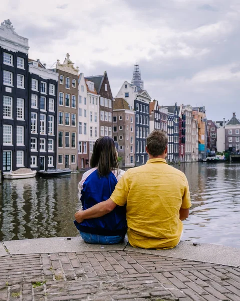 アムステルダムアムステルダムの運河で夏の夜にオランダ、幸せなカップルの男性と女性。男と女中年アジアの女の子とヨーロッパの男性オンシティ旅行 — ストック写真
