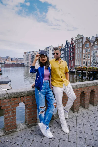 Amsterdam Países Bajos, pareja feliz hombre y mujer en una noche de verano en los canales de Amsterdam. Hombre y mujer de mediana edad chica asiática y hombres europeos en viaje a la ciudad — Foto de Stock