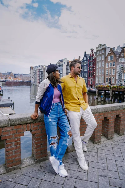 Amsterdam Países Bajos, pareja feliz hombre y mujer en una noche de verano en los canales de Amsterdam. Hombre y mujer de mediana edad chica asiática y hombres europeos en viaje a la ciudad — Foto de Stock