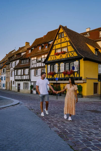 Кольмар, Эльзас, Франция. Petite Venice, water canal and traditional half timbered houses.couple man and woman walking at the street during vacation Colmar is a charming town in Elsace, France — стоковое фото