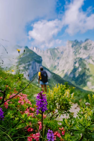 Sırt çantalı bir kadın dağın tepesinde durur, güzel yerlere seyahat eder, hedefe ulaşır, Saxer Luecke 'de dağ sırtı, Alpstein Appenzell Innerrhoden İsviçre' de Kreuzberge 'de. — Stok fotoğraf