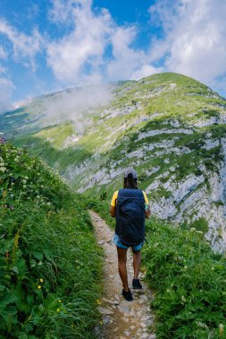 Sırt çantalı bir kadın dağın tepesinde durur, güzel yerlere seyahat eder, hedefe ulaşır, Saxer Luecke 'de dağ sırtı, Alpstein Appenzell Innerrhoden İsviçre' de Kreuzberge 'de.