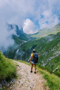 Sırt çantalı bir kadın dağın tepesinde durur, güzel yerlere seyahat eder, hedefe ulaşır, Saxer Luecke 'de dağ sırtı, Alpstein Appenzell Innerrhoden İsviçre' de Kreuzberge 'de.