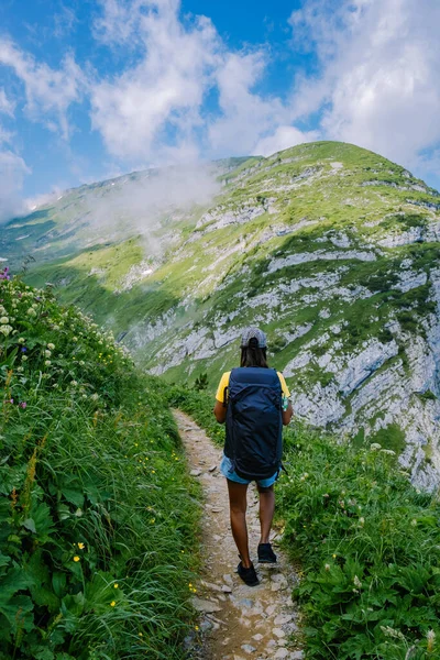 Sırt çantalı bir kadın dağın tepesinde durur, güzel yerlere seyahat eder, hedefe ulaşır, Saxer Luecke 'de dağ sırtı, Alpstein Appenzell Innerrhoden İsviçre' de Kreuzberge 'de. — Stok fotoğraf