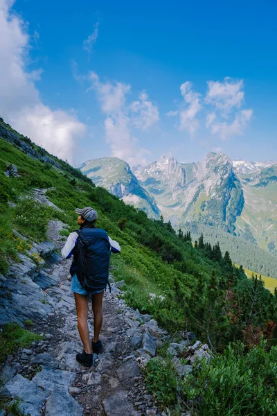 Sırt çantalı bir kadın dağın tepesinde durur, güzel yerlere seyahat eder, hedefe ulaşır, Saxer Luecke 'de dağ sırtı, Alpstein Appenzell Innerrhoden İsviçre' de Kreuzberge 'de. — Stok fotoğraf