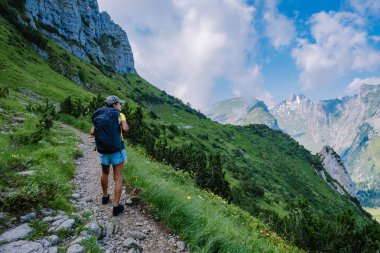 Sırt çantalı bir kadın dağın tepesinde durur, güzel yerlere seyahat eder, hedefe ulaşır, Saxer Luecke 'de dağ sırtı, Alpstein Appenzell Innerrhoden İsviçre' de Kreuzberge 'de.