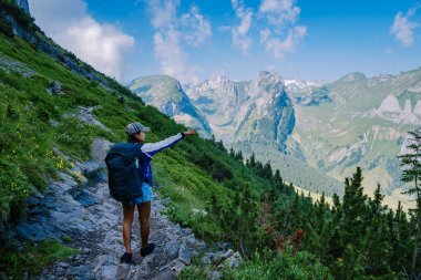 Sırt çantalı bir kadın dağın tepesinde durur, güzel yerlere seyahat eder, hedefe ulaşır, Saxer Luecke 'de dağ sırtı, Alpstein Appenzell Innerrhoden İsviçre' de Kreuzberge 'de.