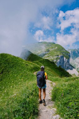 Sırt çantalı bir kadın dağın tepesinde durur, güzel yerlere seyahat eder, hedefe ulaşır, Saxer Luecke 'de dağ sırtı, Alpstein Appenzell Innerrhoden İsviçre' de Kreuzberge 'de.
