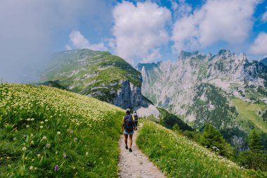 Sırt çantalı bir kadın dağın tepesinde durur, güzel yerlere seyahat eder, hedefe ulaşır, Saxer Luecke 'de dağ sırtı, Alpstein Appenzell Innerrhoden İsviçre' de Kreuzberge 'de.