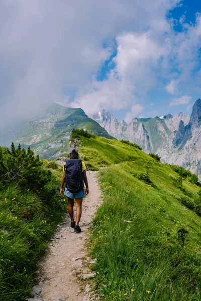 Женщина с рюкзаком стоит на вершине горы, девушка путешествует в красивые места, достигая цели, горный хребет в Саксер-Люкке, Кройцберге в Альпштейне Appenzell Innerrhoden Швейцарии — стоковое фото