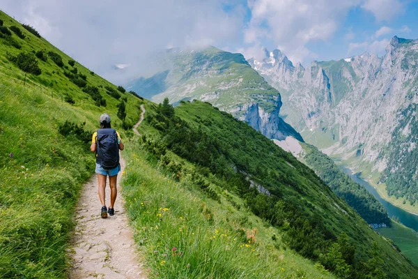 Женщина с рюкзаком стоит на вершине горы, девушка путешествует в красивые места, достигая цели, горный хребет в Саксер-Люкке, Кройцберге в Альпштейне Appenzell Innerrhoden Швейцарии — стоковое фото