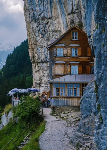 Ελβετικές Άλπεις και ένα εστιατόριο στο βουνό κάτω από τον γκρεμό Aescher θέα από το βουνό Ebenalp στην περιοχή Appenzell στην Ελβετία Aescher γκρεμό — Φωτογραφία Αρχείου