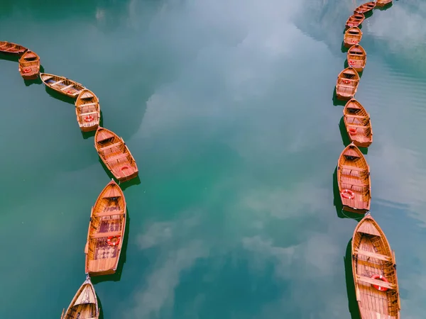 Schöne Landschaft des Pragser Sees romantischer Ort mit Holzbrücke und Booten auf dem Alpensee, Alpen, Dolomiten, Italien, Europa — Stockfoto